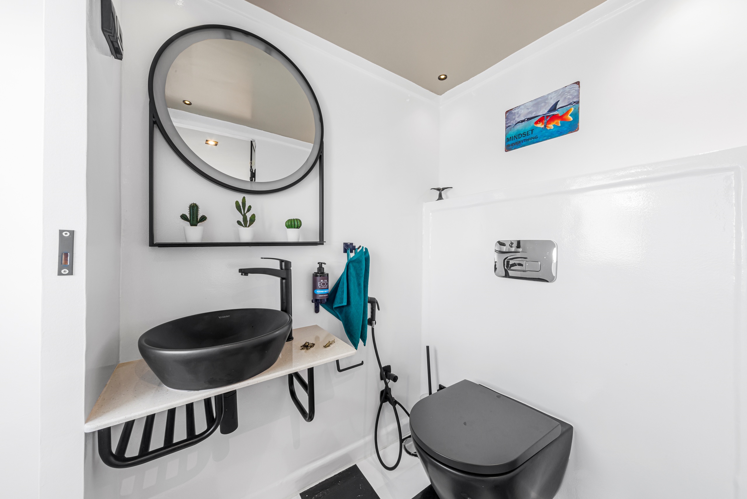 Ein Badbeispiel mit weißen Wänden und schwarzem Waschtisch, Spiegel, schöner Duschbereich im Oberdeck